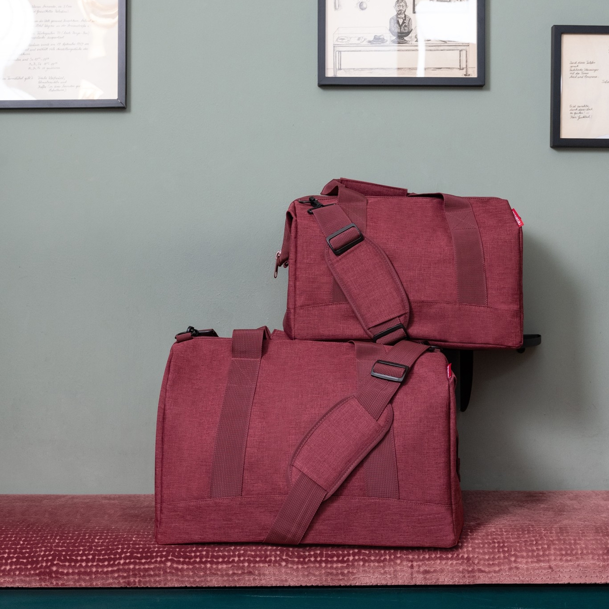 Two burgundy travel bags on bench