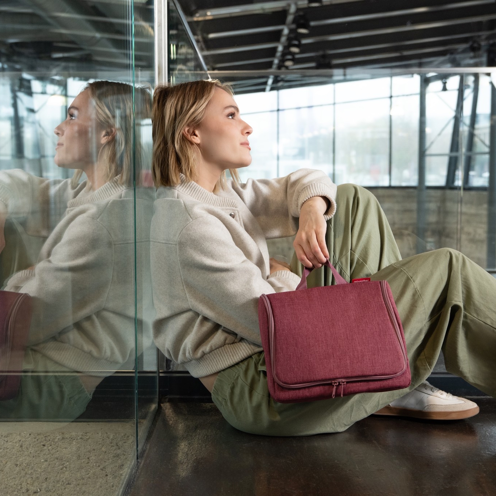 Woman with burgundy wash bag in modern station