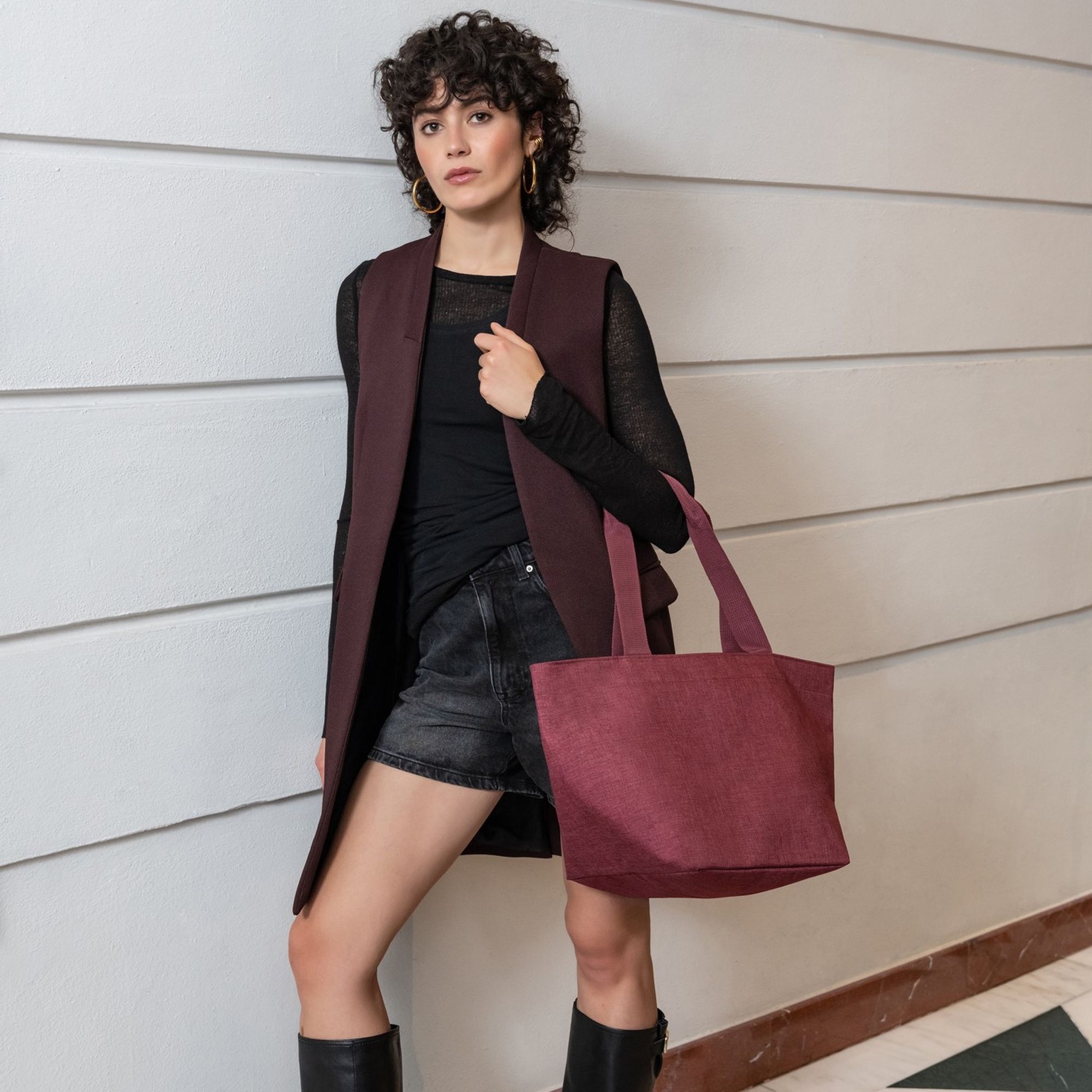 Woman carrying a burgundy fabric tote bag