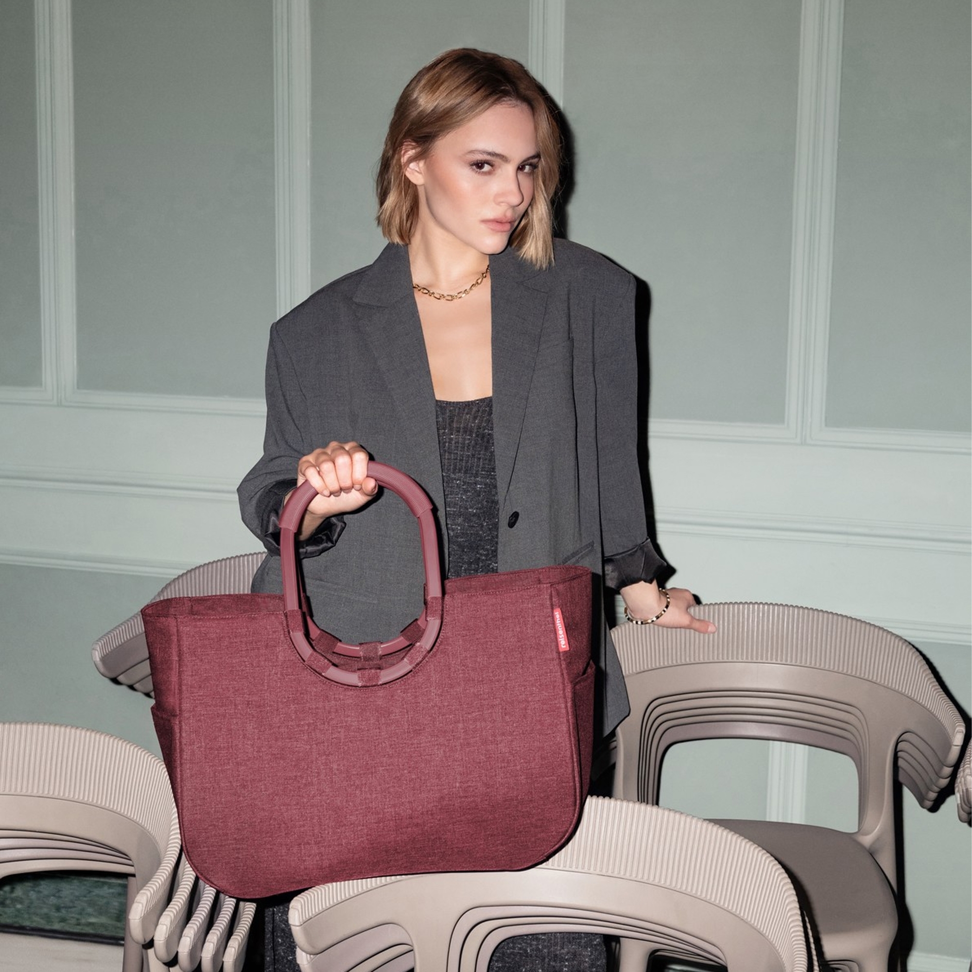 Woman presenting a large burgundy tote bag