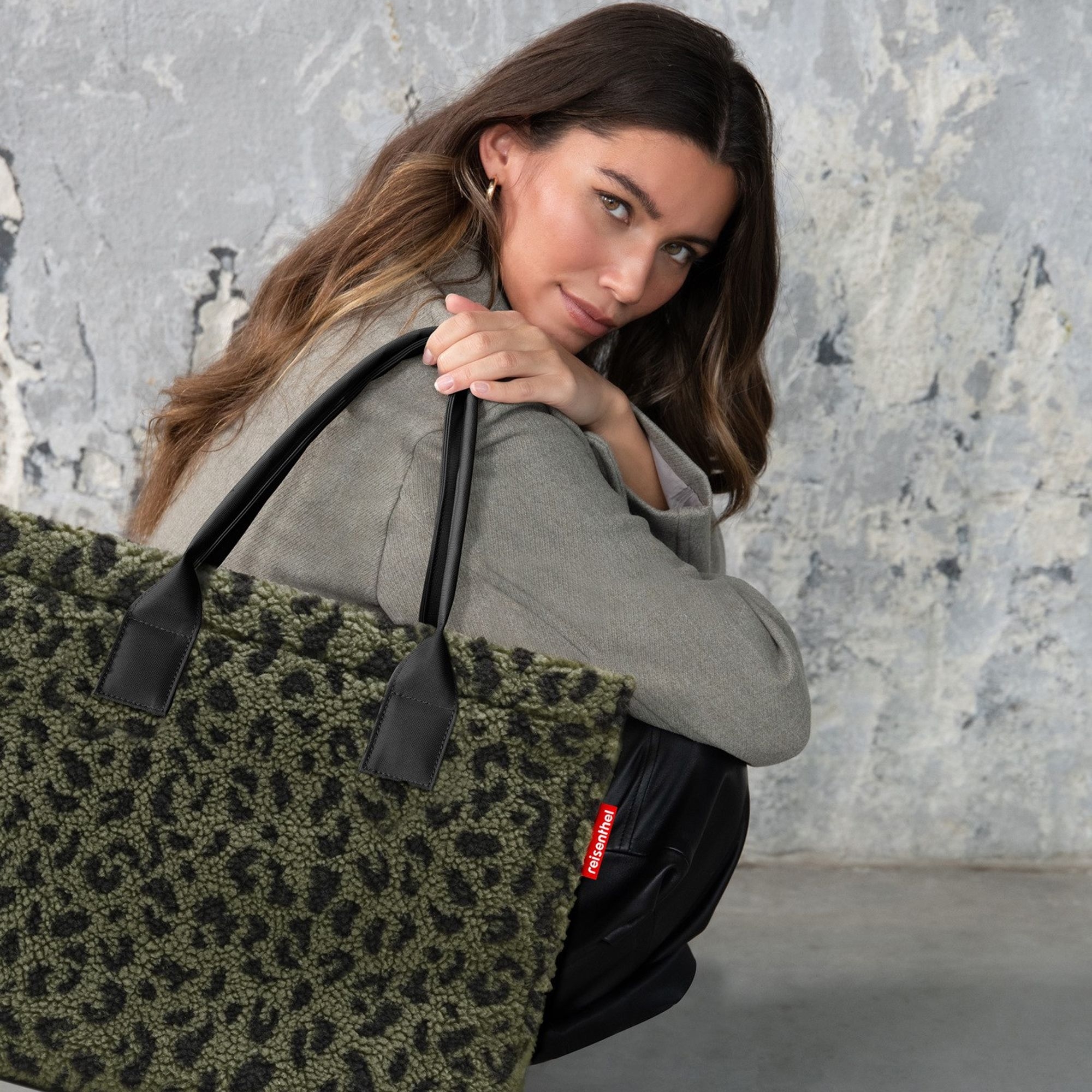 Woman with green leopard print shopper bag and black handles