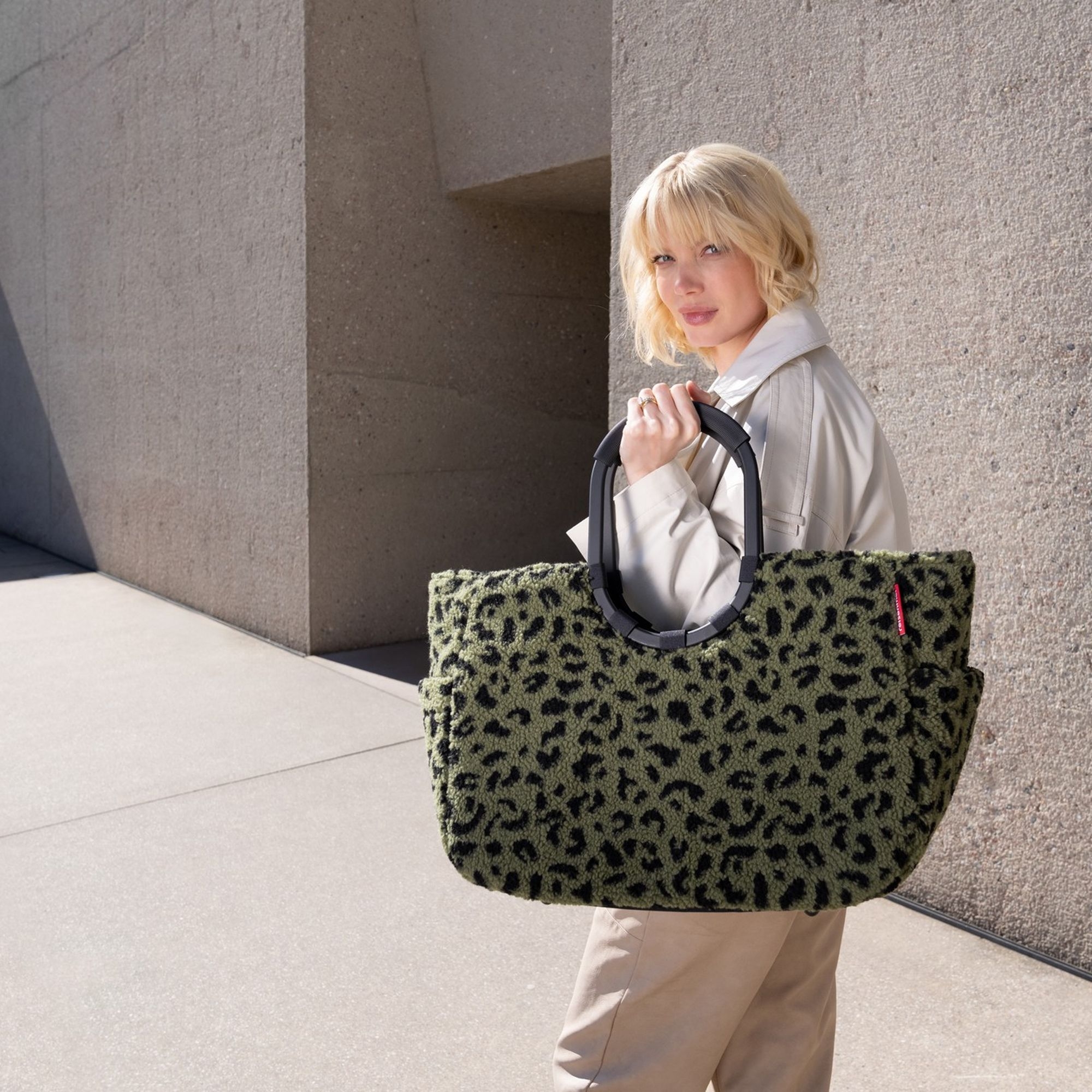 Woman carrying large green leopard print bag