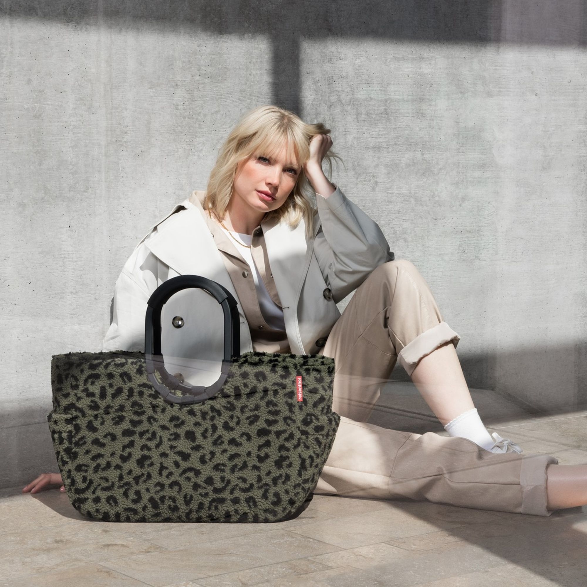 Woman sitting with leopard print bag in beige-cream outfit b