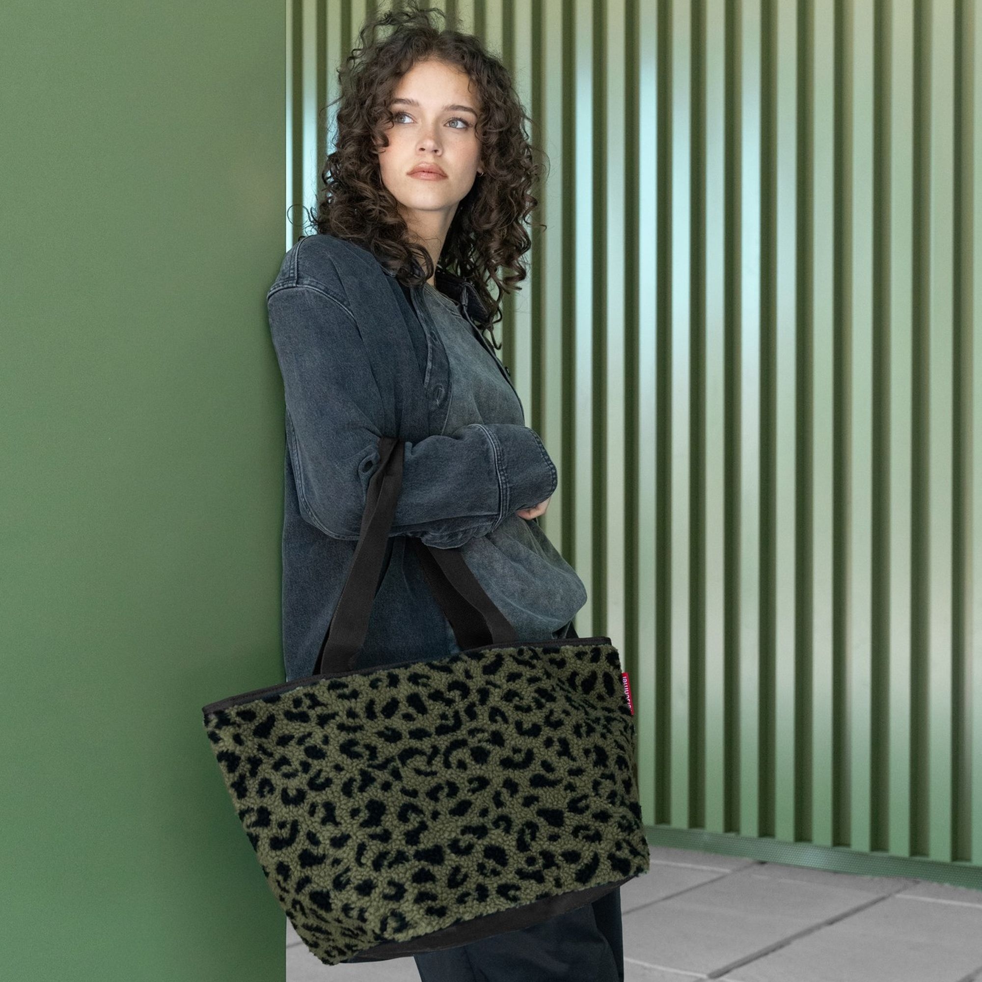 Woman with large green leopard print faux fur bag