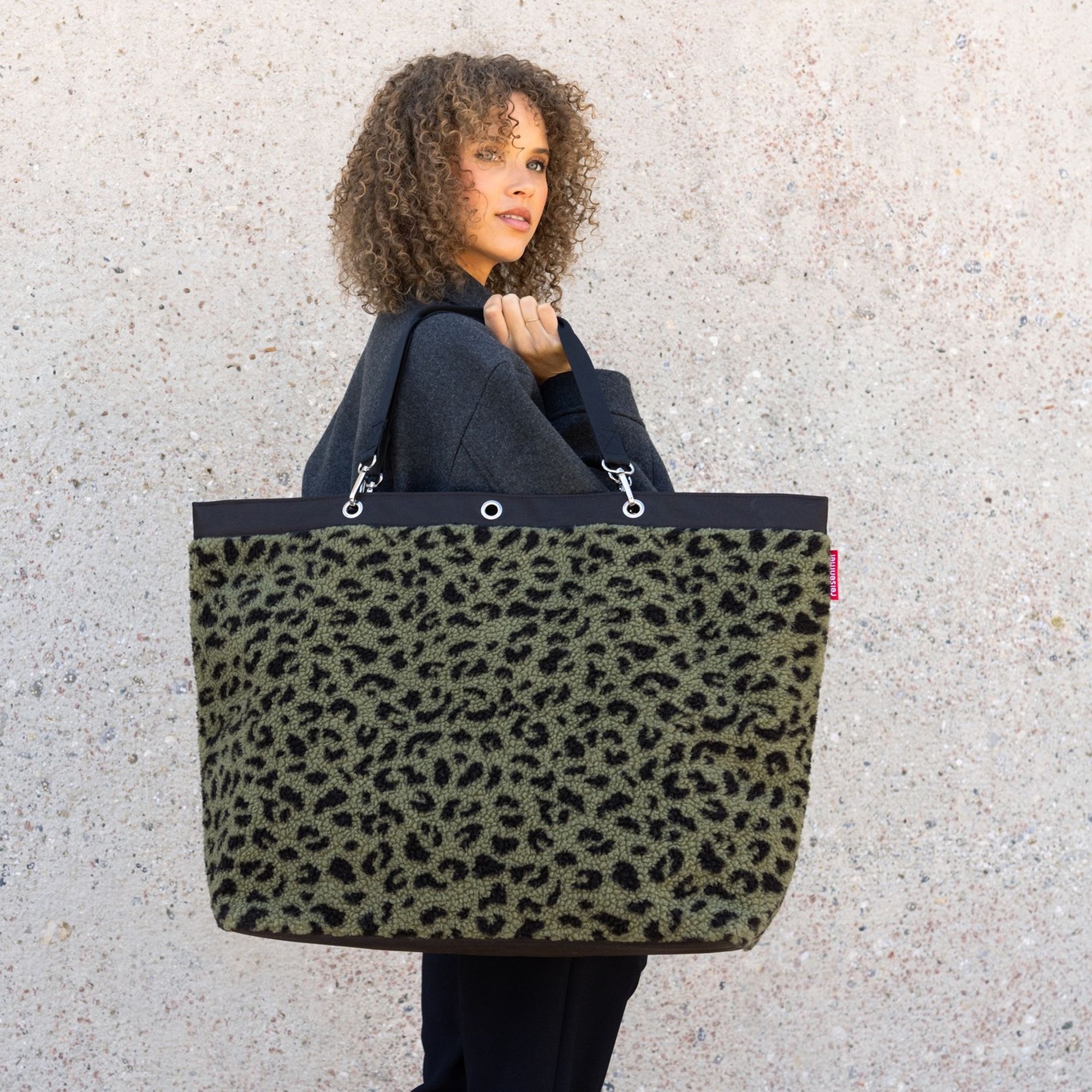 Woman carrying large green leopard print bag