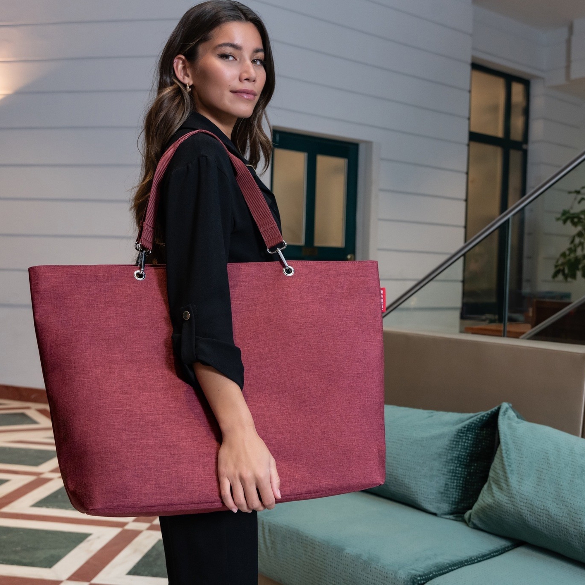 Woman with large red shoulder bag indoors