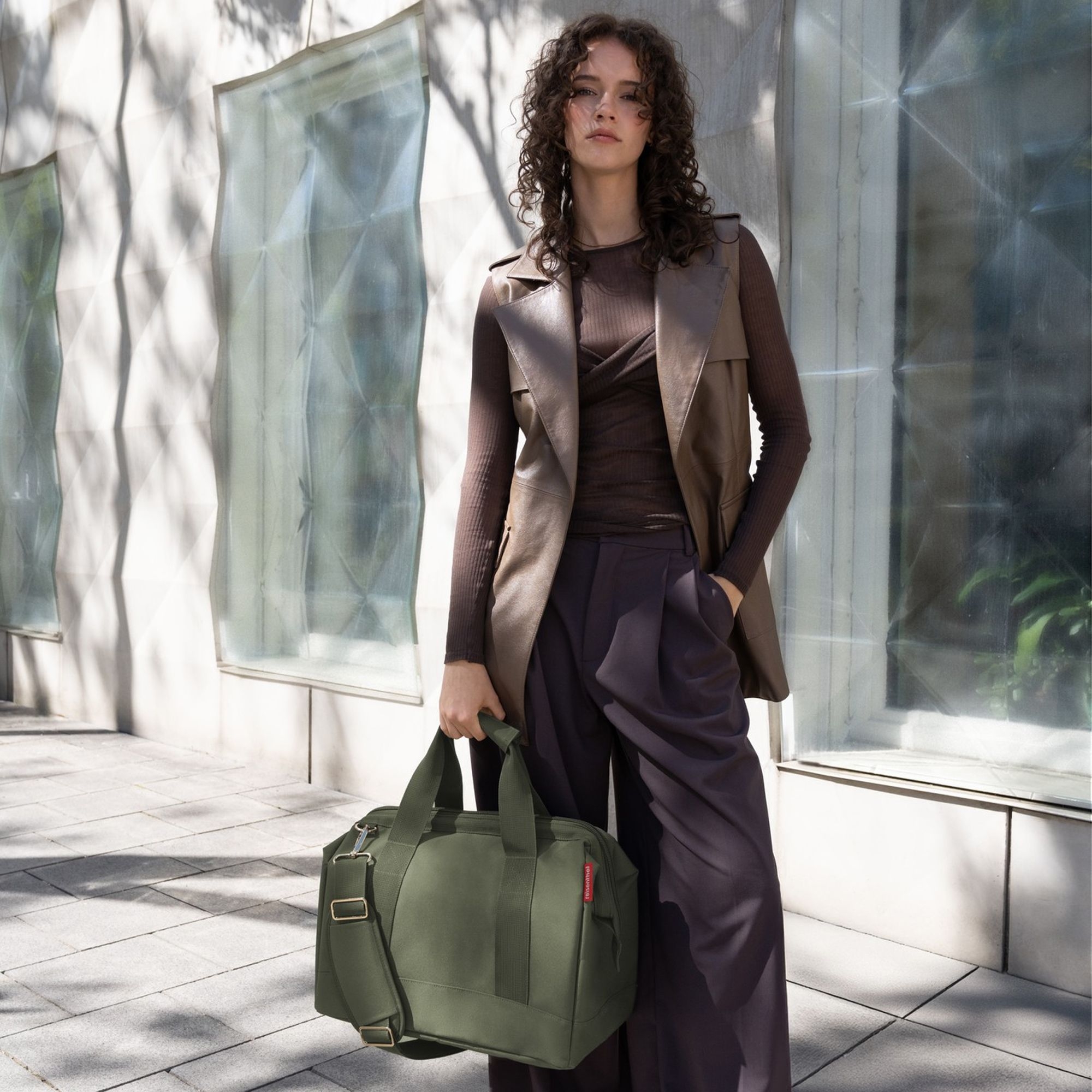 Woman with olive green weekender bag on street